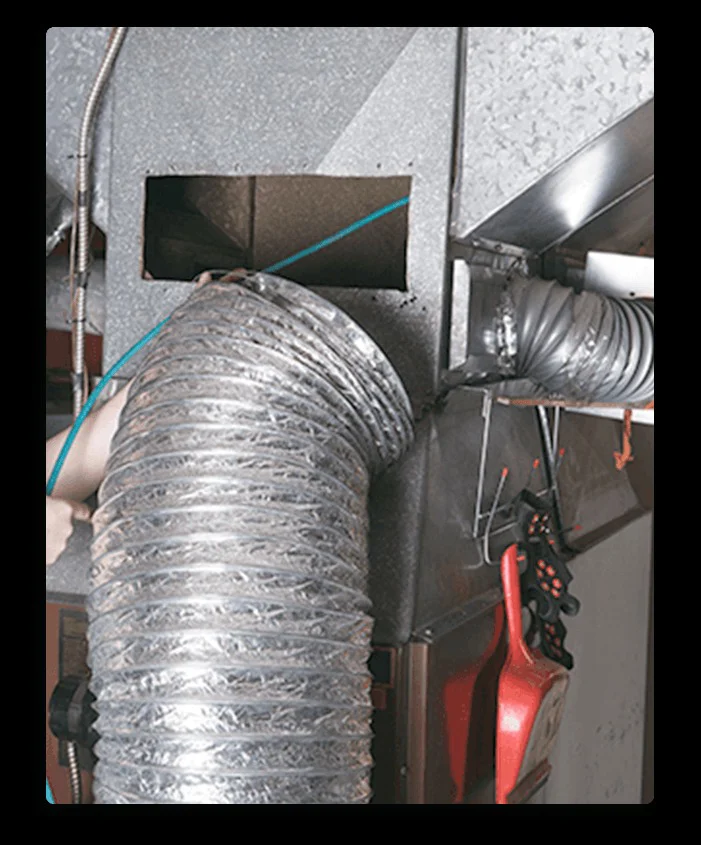 A flexible silver duct connects to HVAC galvanized ductwork