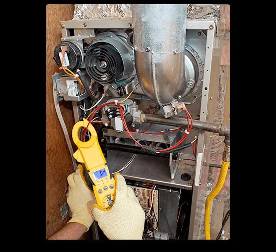A technician's gloved hands use a yellow clamp meter