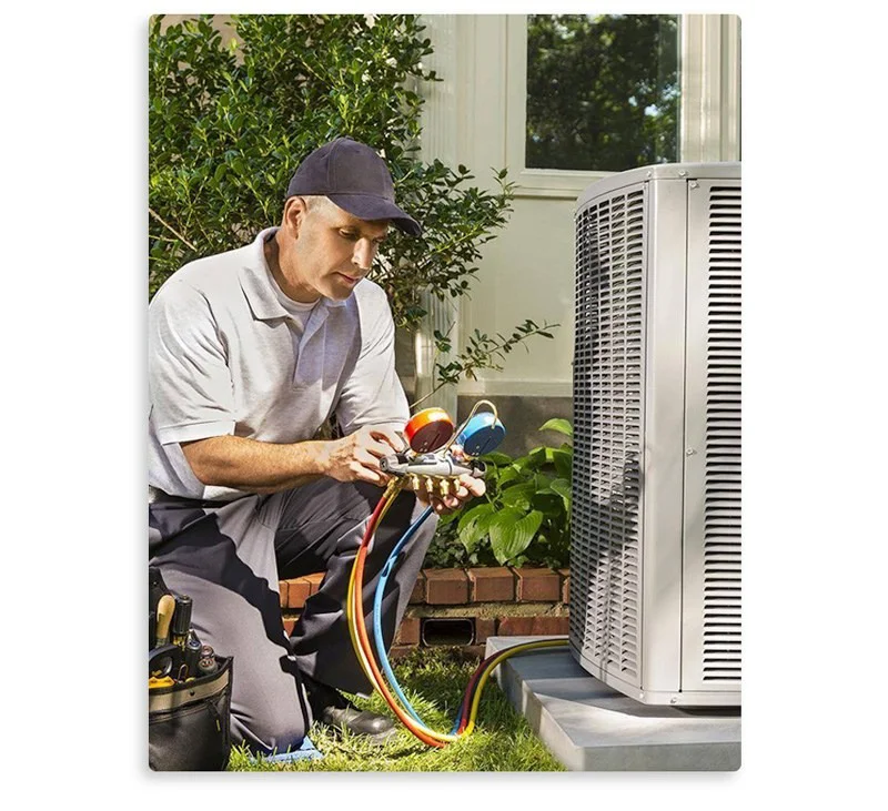 A technician kneels to service an outdoor air conditioning unit